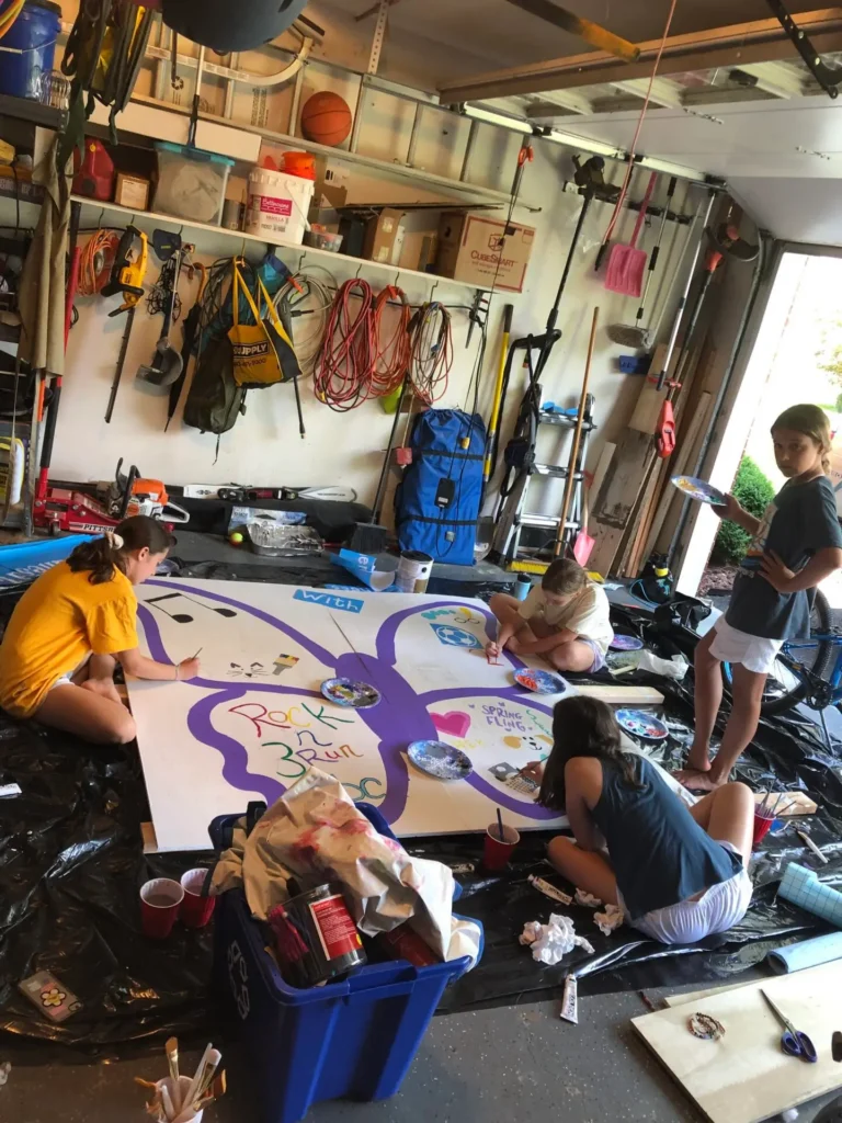 Girls painting butterfly in a garage